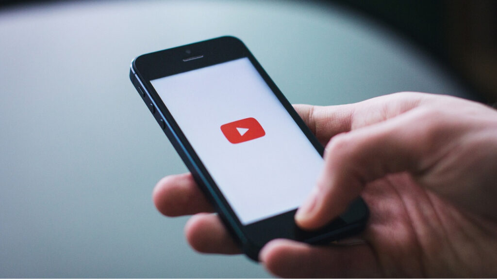 telefon w ręce, na ekranie logo YouTuba
